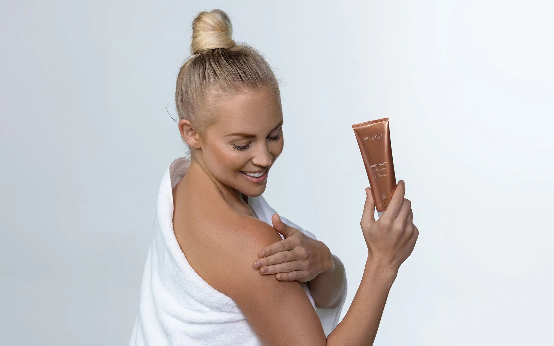 woman applying nu skin cream to shoulder